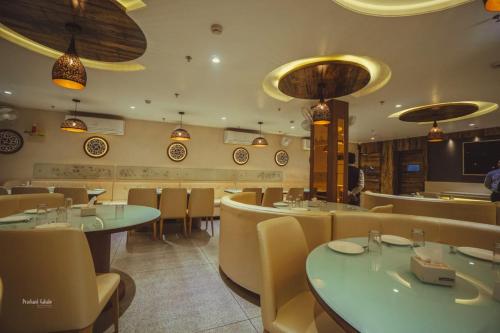 a dining room with tables and chairs in a restaurant at Hotel Ranjeet Akola in Akola