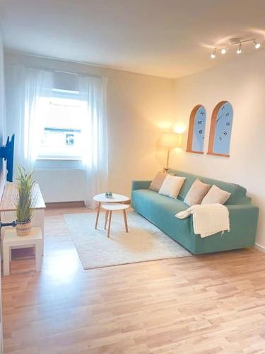 a living room with a green couch and a table at TONY - 2 Zimmer mit Küche - Zentral in Memmingen