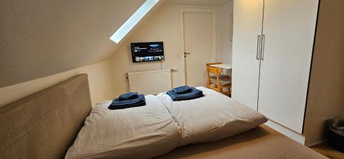 a bedroom with a bed with two blue towels on it at Olsson B&B in Randers