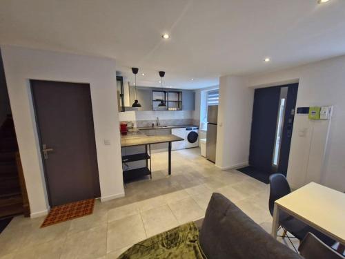 un salon avec une table et une cuisine dans l'établissement Entire house with arcade machine in a private backyard, 3 bedrooms, 1 bathroom, 1 leaving room with convertible sofa and open kitchen, à Mulhouse