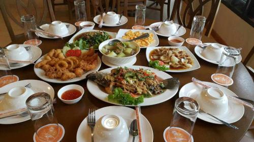 a wooden table with plates of food on it at Sea Sun Beach Resort Koh Kho Khao in Ban Thung Tuk