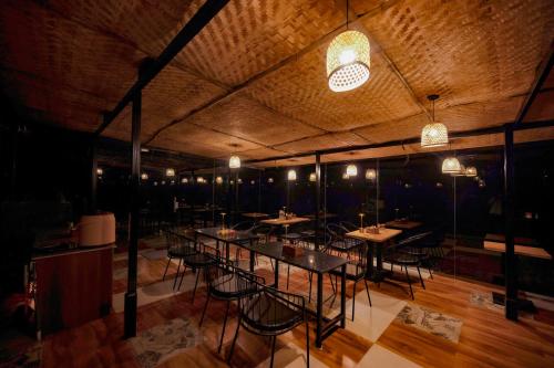 a dining room with tables and chairs and lights at Himadvaya- The Himalayan Prism in Almora