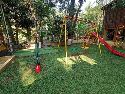 a yard with a playground with a swing set at Coconut Beach Farm in Alibaug