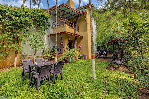 a table and chairs in the yard of a house at Coconut Beach Farm in Alibaug