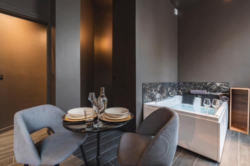d'une salle à manger avec une table, des chaises et une baignoire. dans l'établissement Balnéo des Sacres-Centre Ville, à Reims