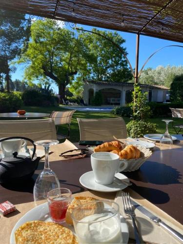 een tafel met brood en koffie en een mandje met gebak bij Logis Hôtel La Sommellerie in Châteauneuf-du-Pape
