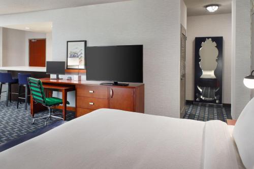 a hotel room with a bed and a desk with a television at Courtyard Arlington Crystal City/Reagan National Airport in Arlington