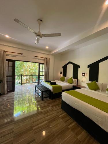 a hotel room with two beds and a balcony at Sundaras Infinity Jungle Resort in Dambulla