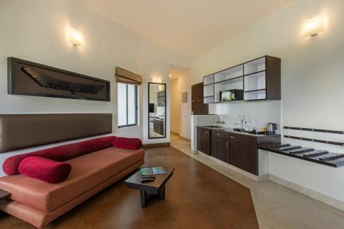 a living room with a couch and a kitchen at Sterling Munnar in Munnar
