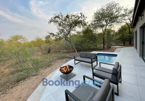 a patio with a fire pit and a swimming pool at Shomoro Rest in Marloth Park