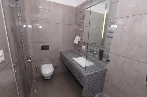 a bathroom with a sink and a toilet and a mirror at The Byke Boutique - Amra Oasis Osian in Osiān