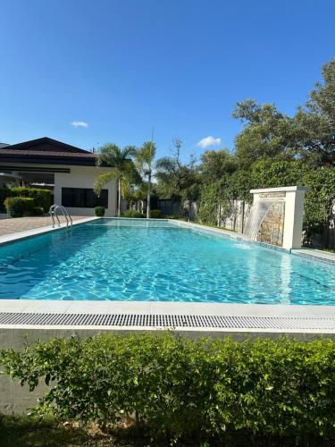een groot blauw zwembad met een fontein bij Cozy Condo Almond drive 1BR Talisay SRP w pool in Tangke