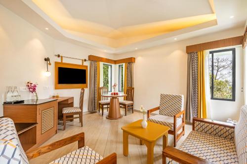a living room filled with furniture and a tv at Sterling Munnar in Munnar