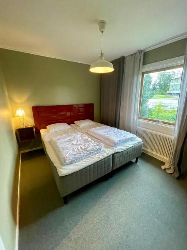 a bedroom with a bed and a window at Fredriksberg Säfsen in Fredriksberg