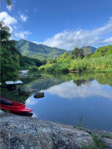 a couple of red boats sitting on the side of a river at บ้านริมชล บ้านสวนสราญชล in Ban Khlong Ha Nua