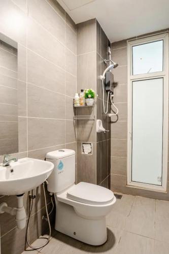 Un baño con inodoro, lavabo y ventana. en Spacious 3BR Condo in Residensi Suasana Damai, en Petaling Jaya