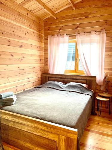 a bedroom with a bed in a log cabin at Ragaciema Skadiņi in Ragaciems