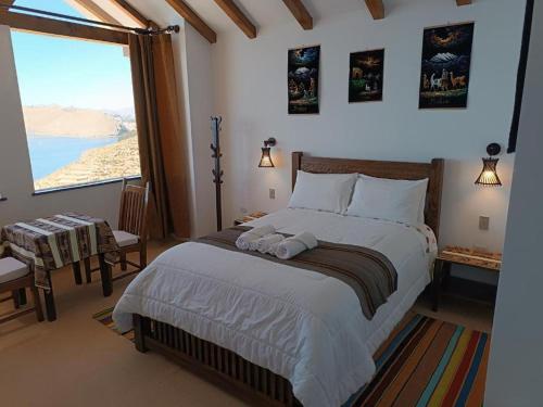 a bedroom with a large bed and a large window at Sol y Luna - ISLA DEL SOL in Comunidad Yumani