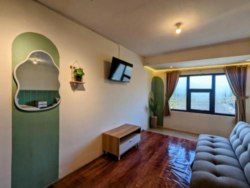a living room with a blue couch and a mirror at Homestay Talago minang dieng in Dieng