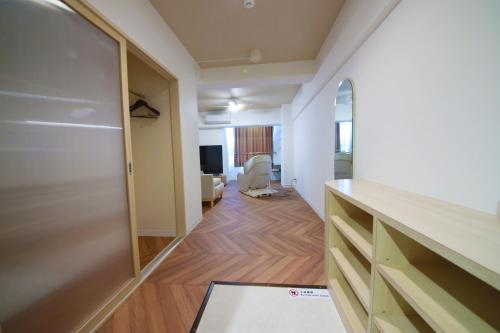 a room with a hallway with a desk and a chair at Miyazaki Mango Hotel in Miyazaki