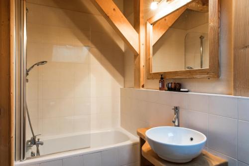 a bathroom with a sink and a bath tub at Chalet Les Drus Luxurious Chalet With Breathtaking Mont Blanc Views From Hot Tub and Garden in Les Houches