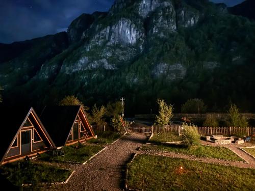 a house in front of a mountain at night at Thethi Villas in Theth
