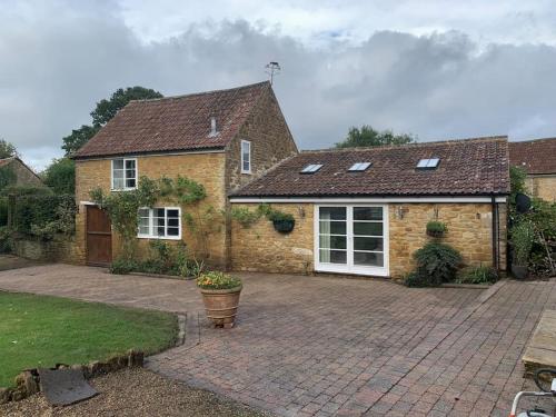 a brick house with a brick driveway at The Cow Shed at Bank Farm in Yeovil