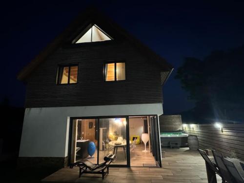 a house with a patio in front of it at night at Chalet design à la mer in Audresselles