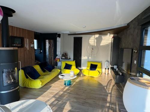 a living room with yellow couch and yellow chairs at Chalet design à la mer in Audresselles
