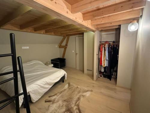 a bedroom with a bed and a closet with clothes at Chalet design à la mer in Audresselles