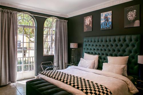 Un dormitorio con una cama grande con cabecero verde. en The White Castle, en Chartwell