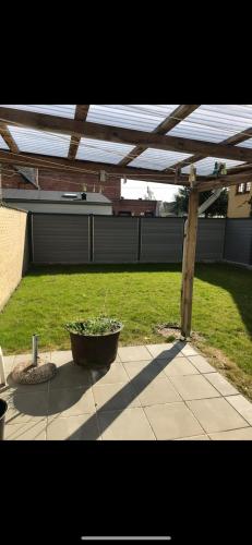 a planter under a wooden pergola on a patio at Stor lejlighed i smørhullet af Odense centrum in Odense