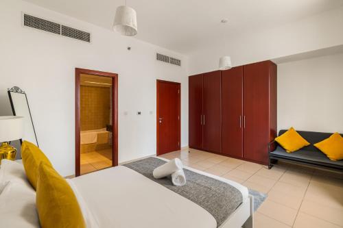 a bedroom with a white bed and a bathroom at Beautiful 2BR & 4BR Apartments on JBR Beach, Walking Distance to Bluewaters Island - By Sunkissed Holiday Homes in Dubai