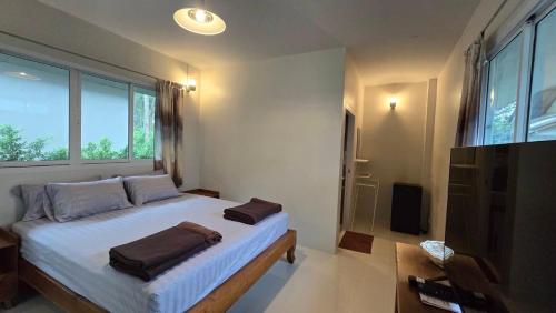 a bedroom with a bed with two towels on it at honeyhome kohkood in Ko Kood