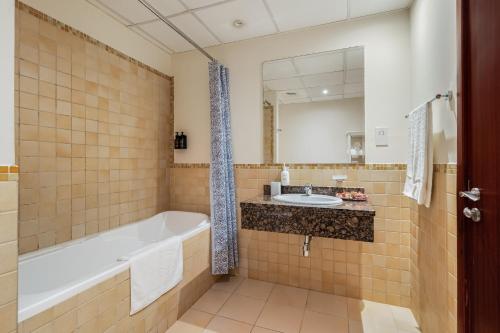 a bathroom with a tub and a sink at Beautiful 2BR & 4BR Apartments on JBR Beach, Walking Distance to Bluewaters Island - By Sunkissed Holiday Homes in Dubai