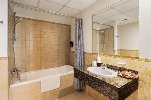 a bathroom with a sink and a bath tub and a mirror at Beautiful 2BR & 4BR Apartments on JBR Beach, Walking Distance to Bluewaters Island - By Sunkissed Holiday Homes in Dubai