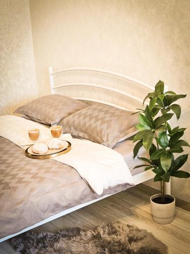 un letto con un vassoio di cibo e una pianta sopra di Апартаменты на Вечернем бульваре # Качалова a Kryvyj Rih
