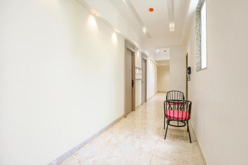 a chair in the hallway of a building at FabHotel Melody Boutique - Village Vadavali, Thane in Thane