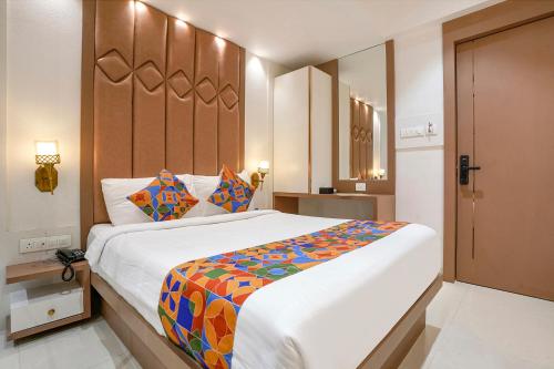 a bedroom with a large bed with a colorful blanket at FabHotel Melody Boutique - Village Vadavali, Thane in Thane