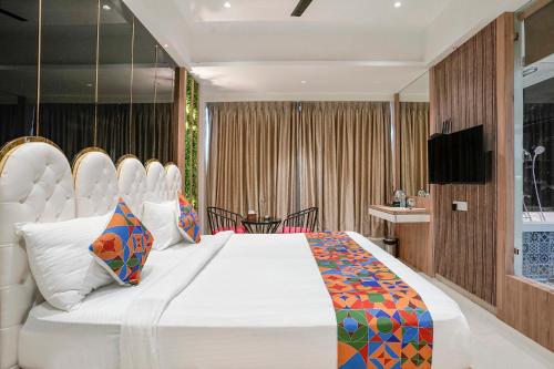 a bedroom with a large white bed and a television at FabHotel Melody Boutique - Village Vadavali, Thane in Thane