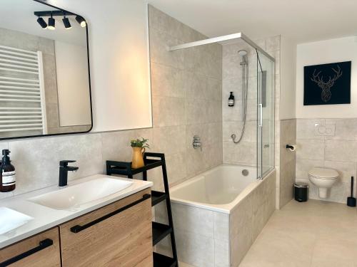 Un baño con bañera, lavabo y ducha. en 103 m2 geräumiges familienfreundliche Ferienwohnung mit Infrarotsauna in Erfurt, en Erfurt