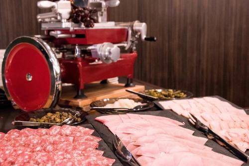a table with different types of meat and a machine at Le Méridien Paris Arc De Triomphe in Paris