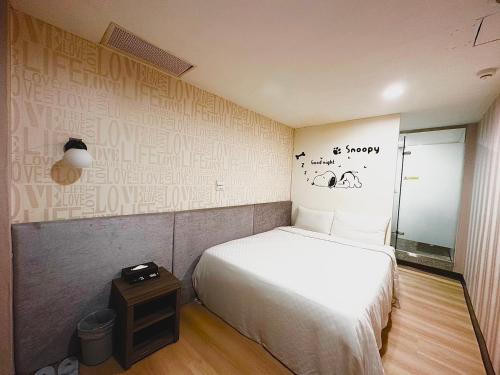 a small bedroom with a bed and a mirror at Walker Hotel - Zhengyi 2 in Taipei