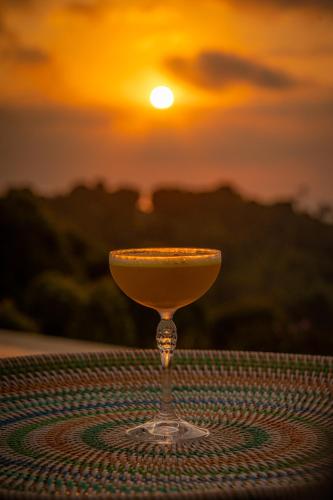 a drink on a table with the sunset in the background at Umah Lusa in Munduk