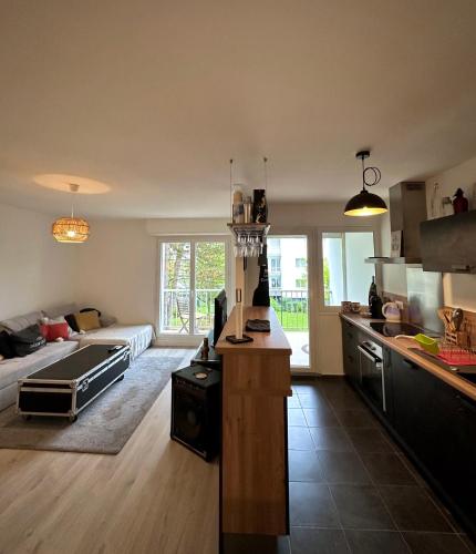 une cuisine et un salon avec un canapé et une table dans l'établissement Le Beau Hugo, à Mainvilliers