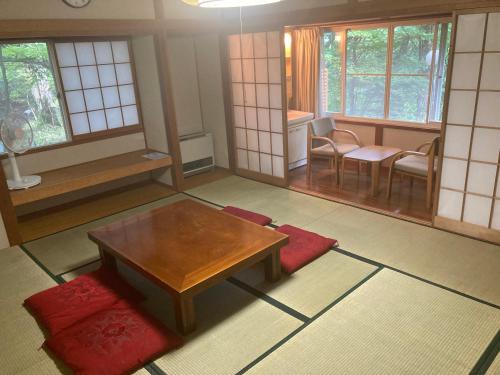 軽井沢町にある余裕堂軽井沢山荘のリビングルーム(テーブル、椅子、窓付)