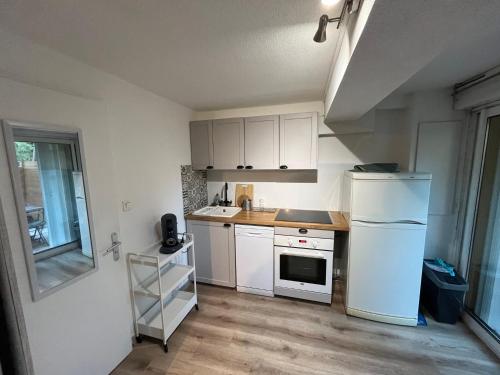 a kitchen with white cabinets and a white refrigerator at Le Relais de la Calèche in Le Beausset