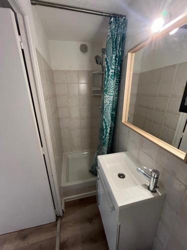 a white bathroom with a sink and a shower at Le Relais de la Calèche in Le Beausset