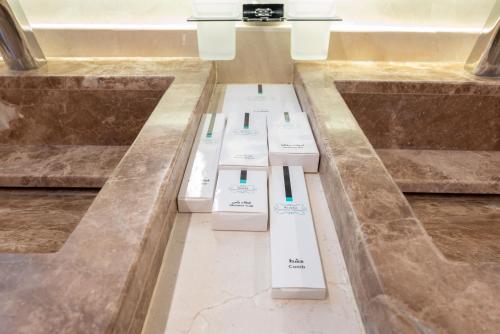 a row of toothbrushes sitting on the floor in a bathroom at Vender Hotel in Taif