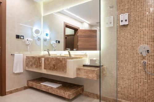 a bathroom with a sink and a shower at Vender Hotel in Taif